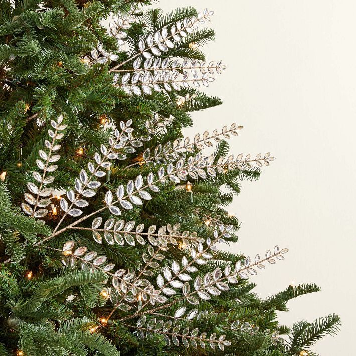Close-up of Christmas tree decorated with layered crystal leaf picks for a full, elegant, and designer-inspired look.