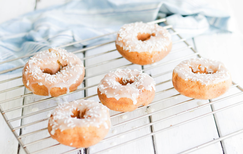 Soft lemon cake donuts are topped with a sweet icing and crunchy coconut flakes. 