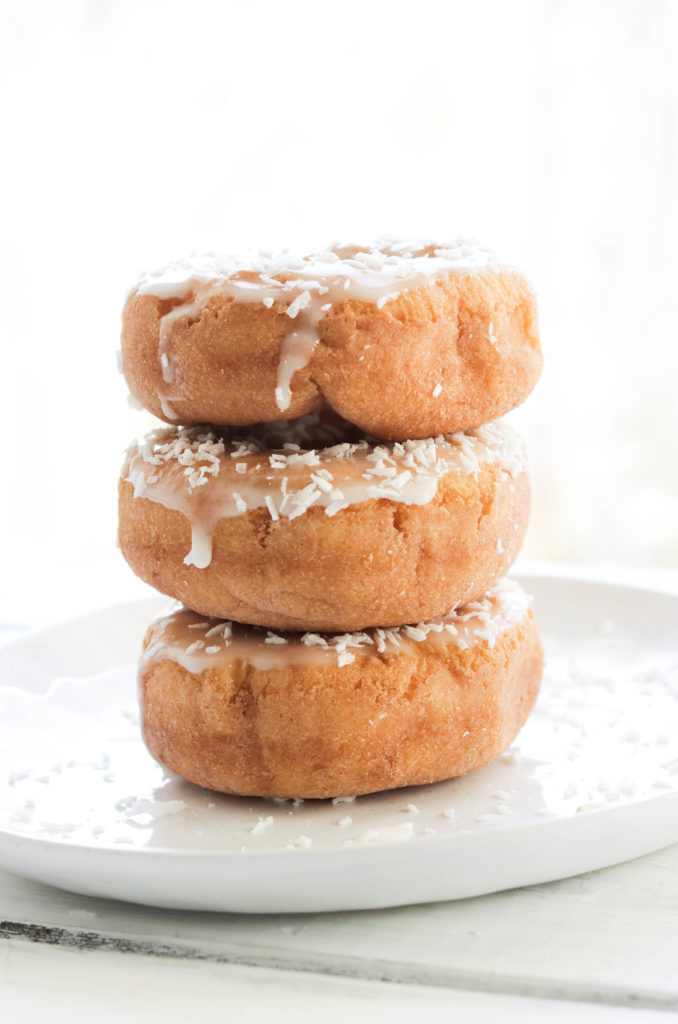 Delicious lemon cake donuts topped with a lemon infused icing and coconut flakes.