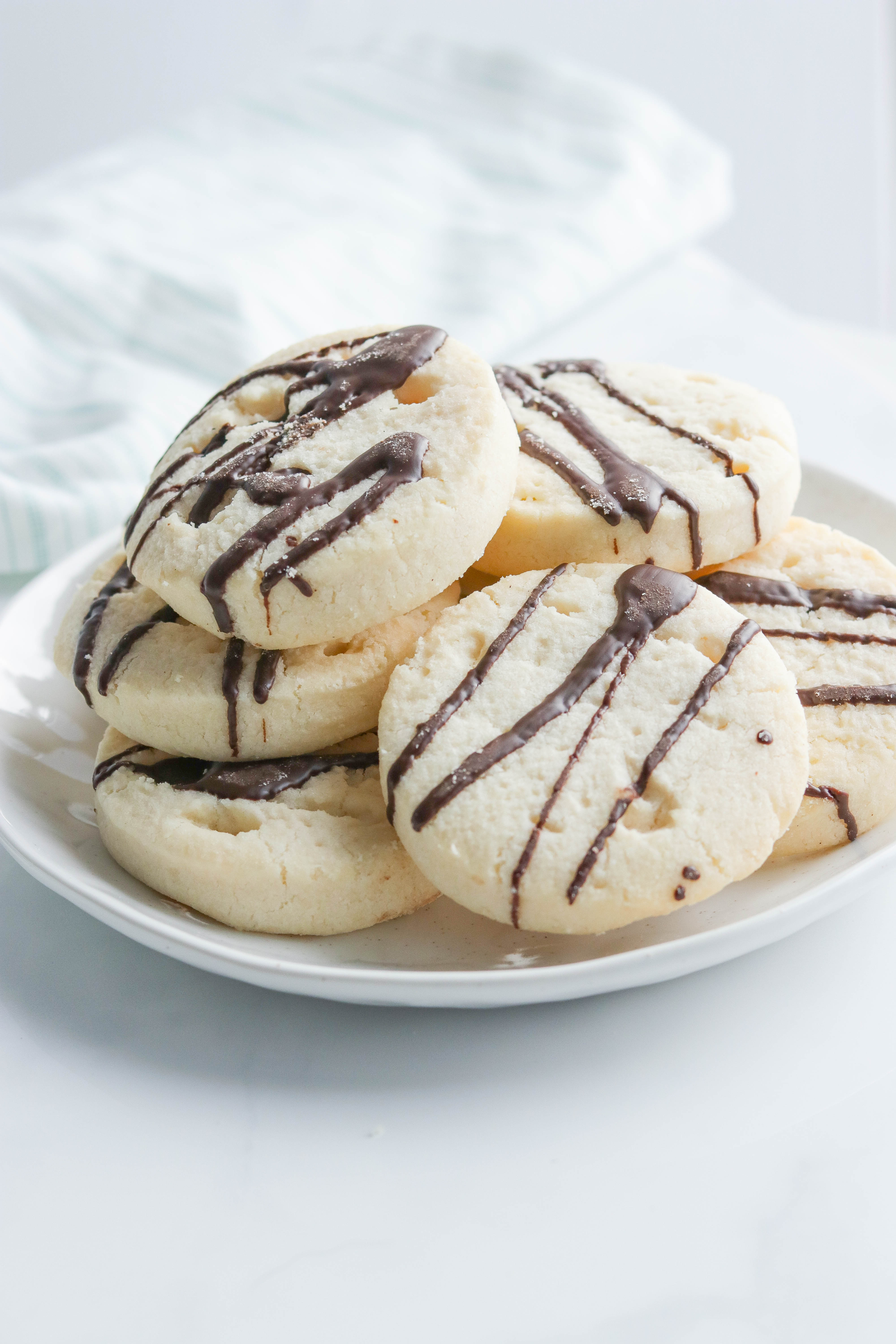 Sugar Free Cookies {Vegan + Gluten Free} || Soft and delicious gluten free and vegan sugar cookies with a dark chocolate drizzle. Taking this holiday cookie to a new healthier level. Quick and easy to make. Please the entire family! #sugarcookies #holidaycookies #christmasbaking #glutenfree #vegan || Nikki's Plate