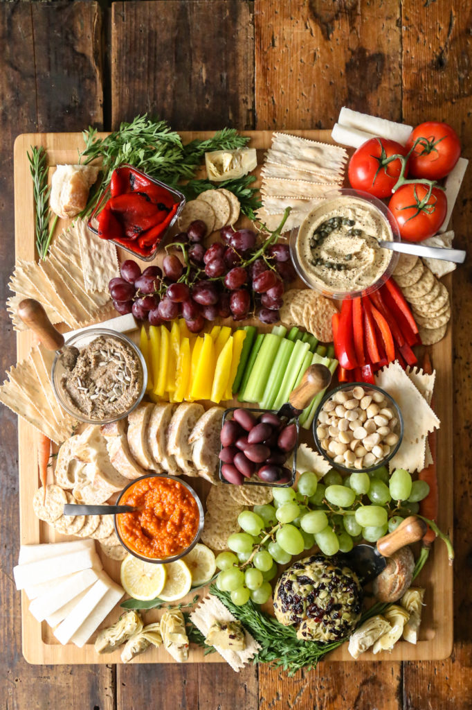 this vegan charcuterie board focuses on different crackers and crisp, colorful veggies and nuts