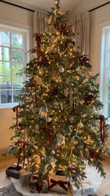 Cozy farmhouse Christmas tree decorated with warm white lights, velvet ribbon, and natural ornaments for a timeless holiday look.
