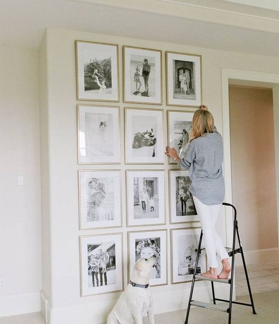 This full-wall gallery wall is a great accent, with slim gold picture frames and black and white pictures