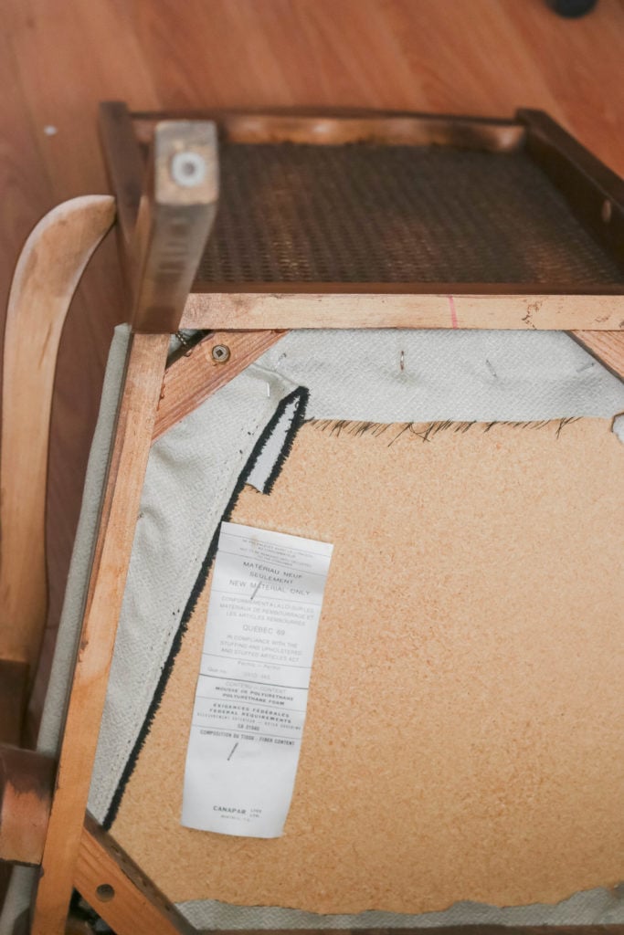 Removing the seat from this old antique office chair so we can reupholster it with updated fabric.