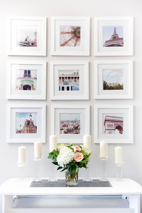 This gallery wall has bright color pictures of famous landmarks, all in simple white picture frames