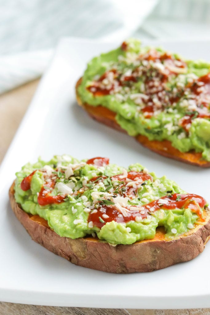 Hearty sweet potato slices topped with creamy avocado, cheese, hemp seeds, and a drizzle of hot sauce