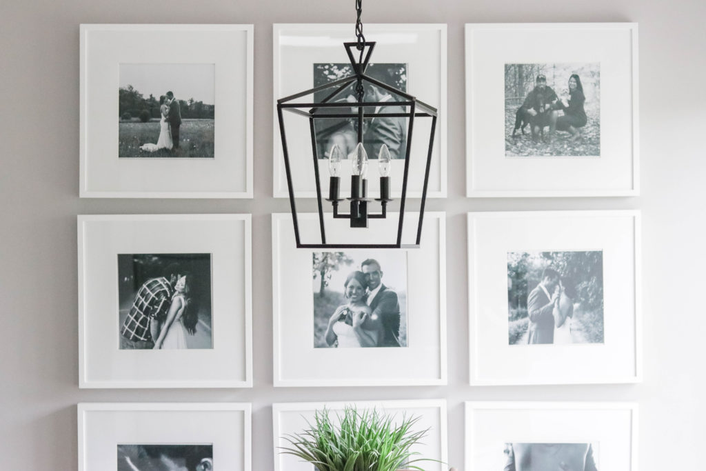 We created a large gallery wall in our living room using black and white pictures in simple white picture frames