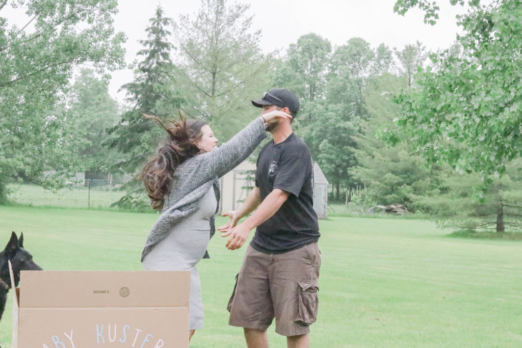 Gender Reveal Party - mom and dad to be reaching for a hug