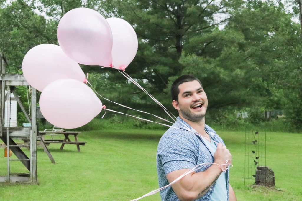 Gender Reveal Party - brother holding pink balloons