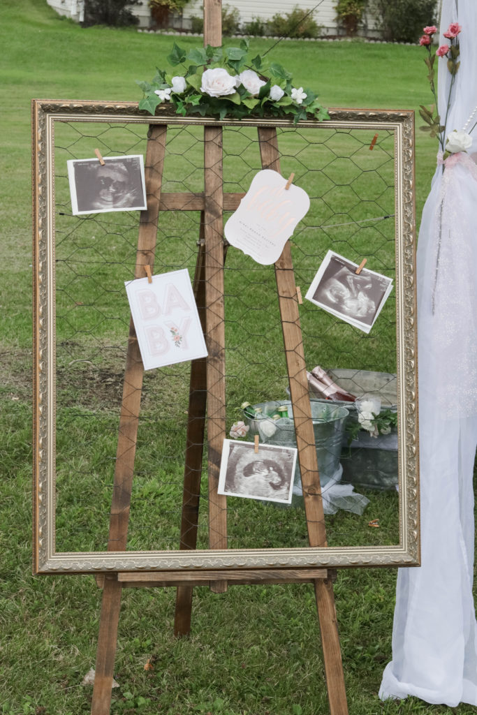 This DIY pretty in pink baby shower decor had a large picture frame holding our baby announcements and sonograms