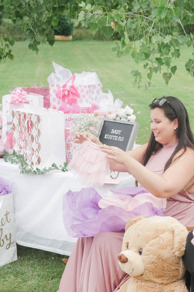 Nikki opening gifts and showing friends and family the adorable baby tutu gifted to Baby Kusters!