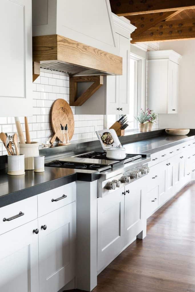 11 Best Kitchens by Studio McGee; This farmhouse style kitchen is bright and bold with dark countertops and clean white cabinets