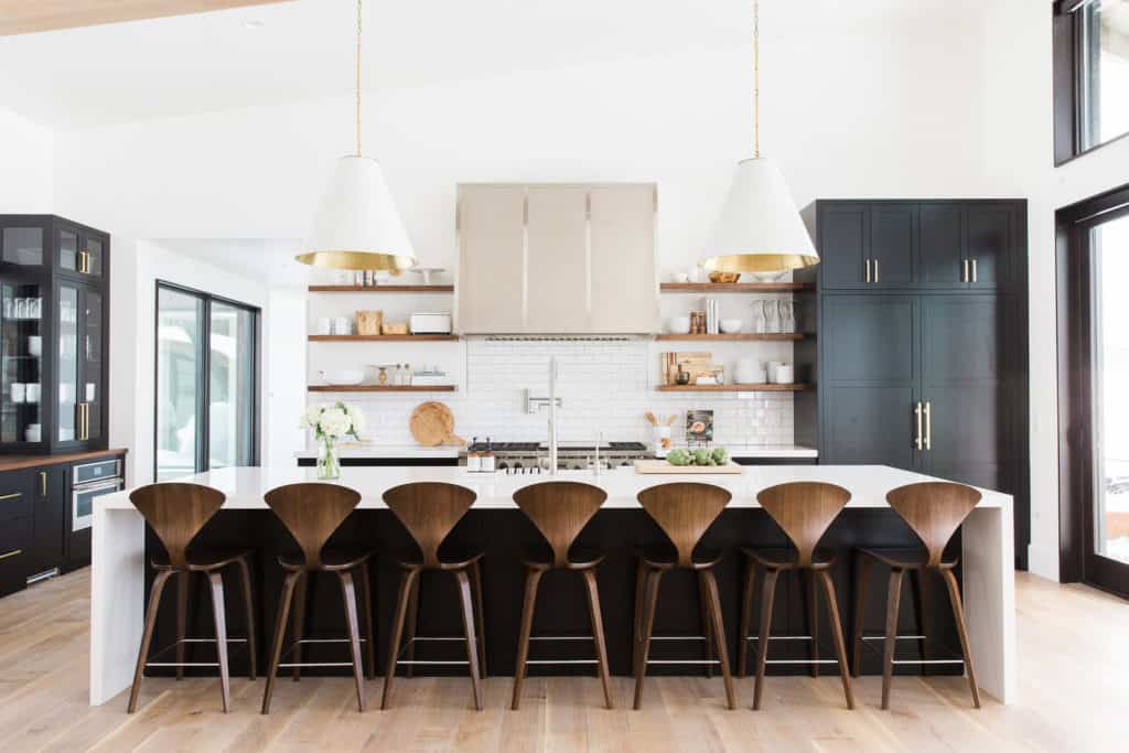 11 Best Kitchens by Studio McGee; This large kitchen makes a bold statement with black accents to complement the mostly white decor. I love the black cabinets and breakfast island!