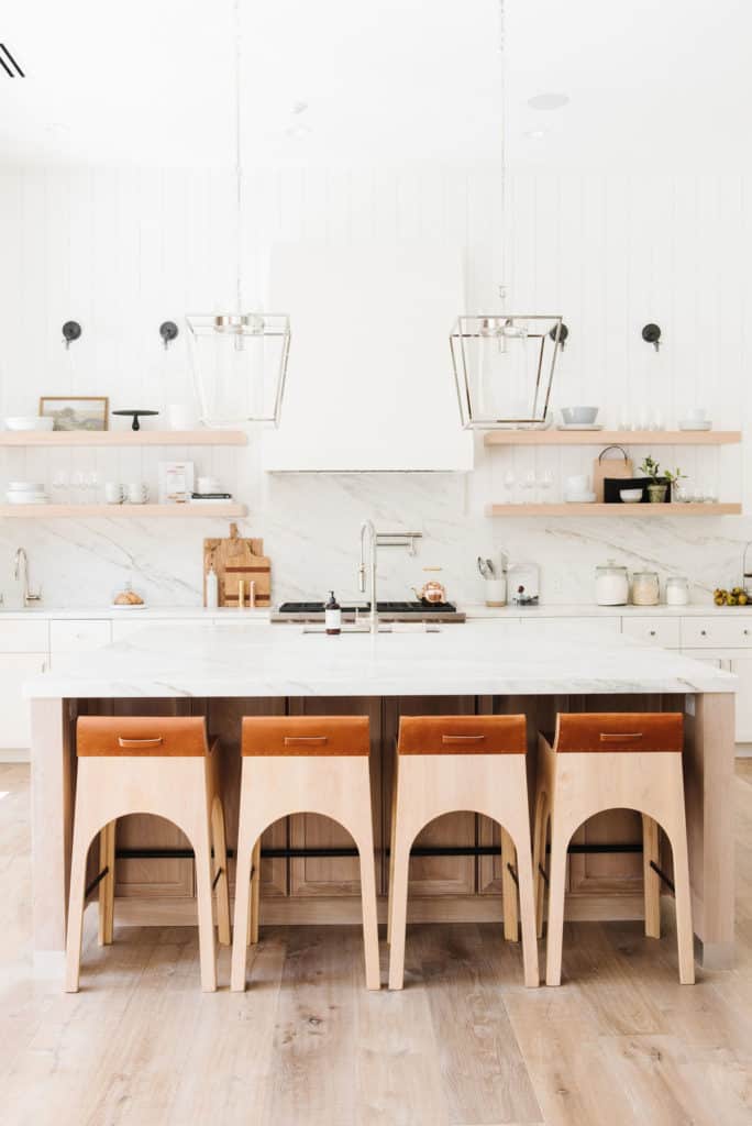 11 Best Kitchens by Studio McGee; This modern style lakehouse kitchen is so clean and bright! I love the marble backsplash and wooden breakfast bar chairs