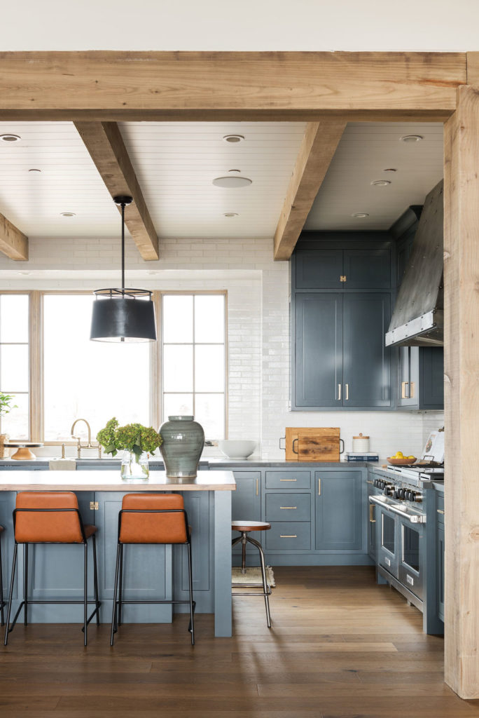 11 Best Kitchens by Studio McGee; This modern country style kitchen has gorgeous cobalt blue cabinets, which look great with the white brick backsplash