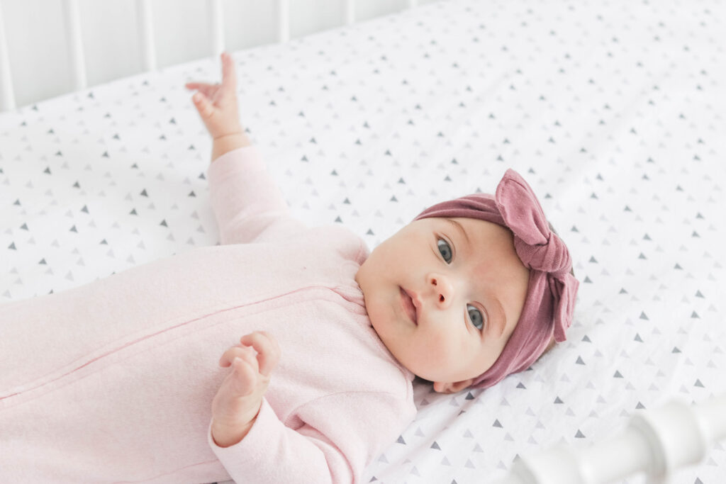 Elliott's White Vintage Crib; White walls, cursive name sign on wall, wainscotting, bright white baby girl room. #babygirlnursery || Nikki's Plate