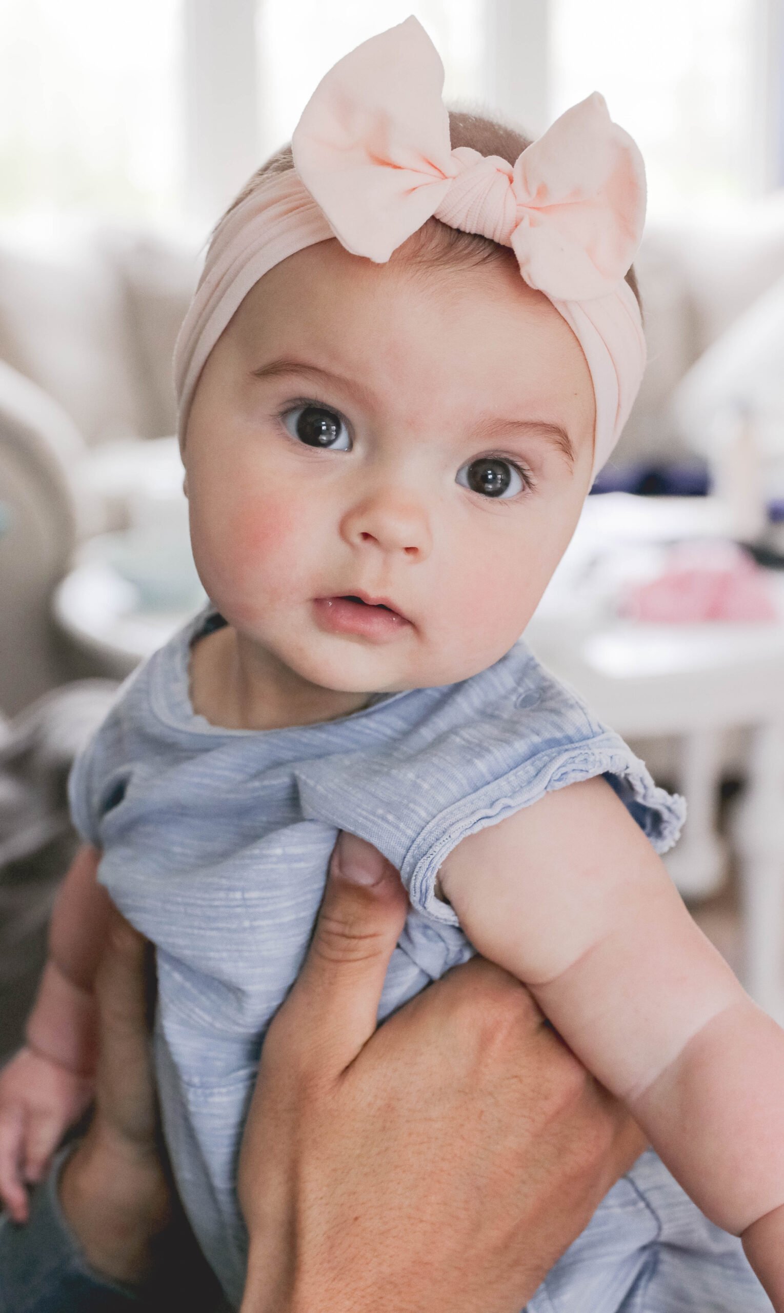 6 month old schedule - day in the life of a baby - infant girl with blue onesie and pink headband on. Baby photography