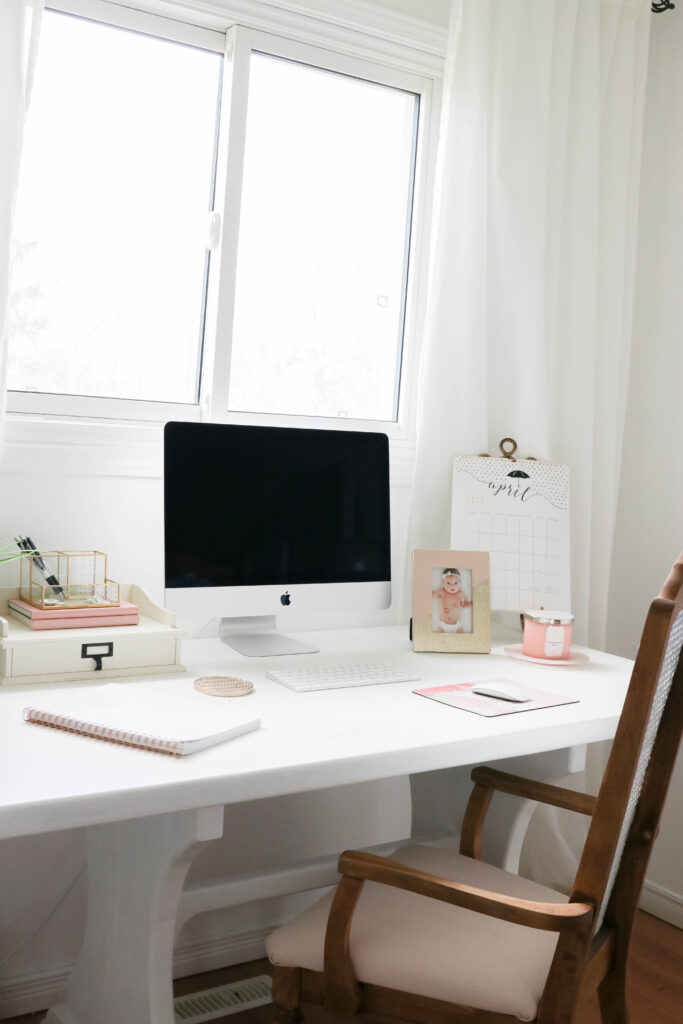 Girly White office with vintage wood chair, iMac computer, greenery, tall calendar, white vintage chair, daughter framed picture, white linen drapes || Nikki's Plate