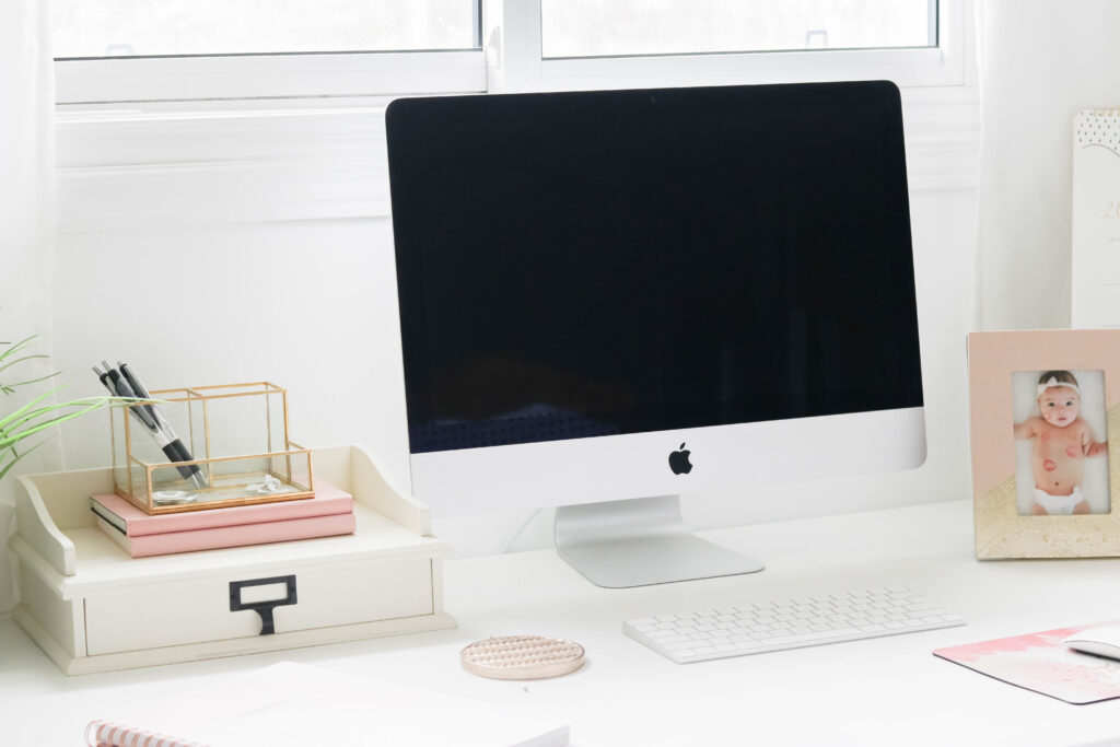 Girly White office with vintage wood chair, iMac computer, greenery, tall calendar, white vintage chair, daughter framed picture, white linen drapes || Nikki's Plate