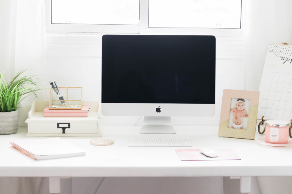 Girly White office with vintage wood chair, iMac computer, greenery, tall calendar, white vintage chair, daughter framed picture, white linen drapes || Nikki's Plate