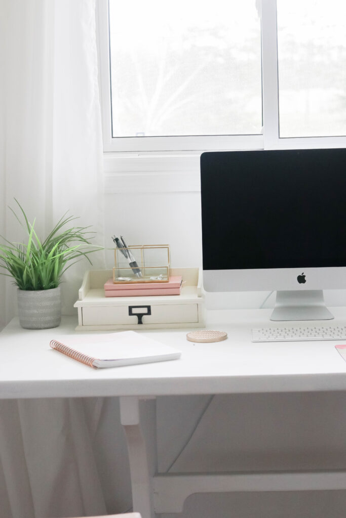 Girly White office with vintage wood chair, iMac computer, greenery, tall calendar, white vintage chair, daughter framed picture, white linen drapes || Nikki's Plate