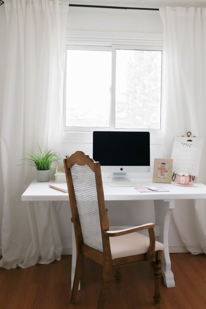 Girly White office with vintage wood chair, iMac computer, greenery, tall calendar, white vintage chair, daughter framed picture, white linen drapes || Nikki's Plate