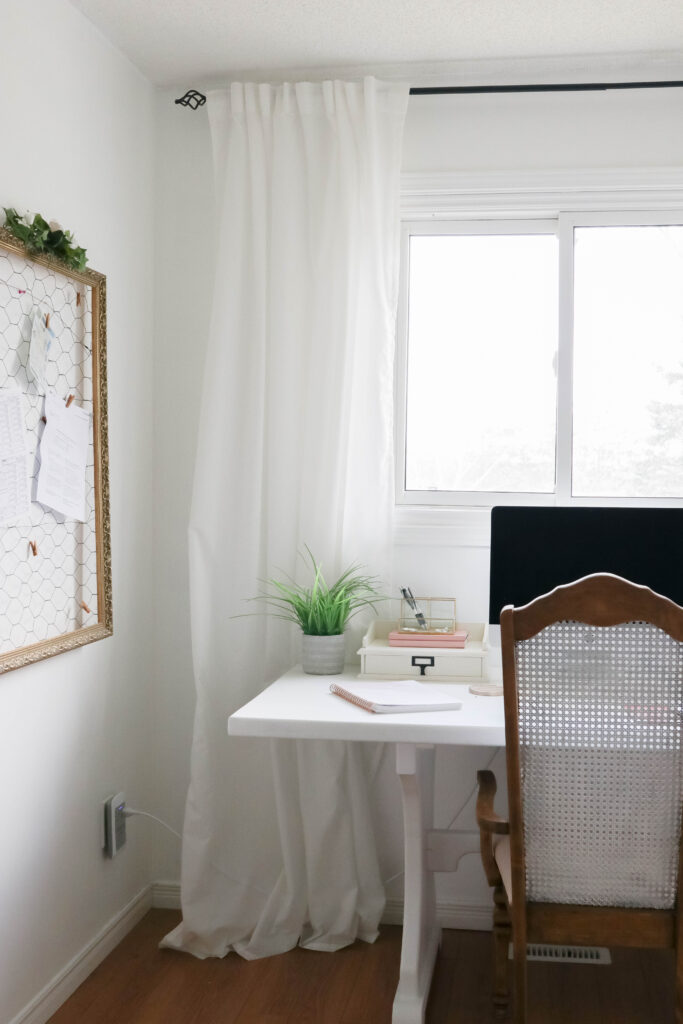 Girly White office with vintage wood chair, iMac computer, greenery, tall calendar, white vintage chair, daughter framed picture, white linen drapes || Nikki's Plate