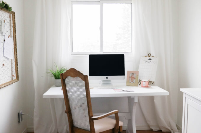 Girly White office with vintage wood chair, iMac computer, greenery, tall calendar, white vintage chair, daughter framed picture, white linen drapes || Nikki's Plate