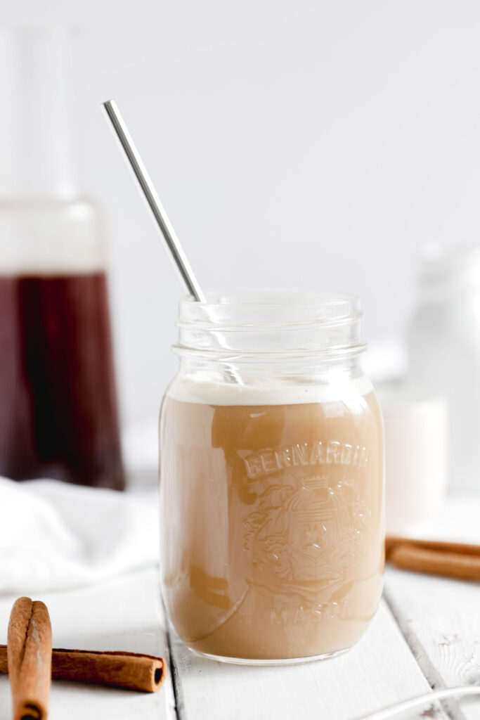Overnight Cinnamon Cold Brew Coffee - mason jar full of cold coffee beverage with stainless steel straw over ice.  Almond milk making it a vegan beverage