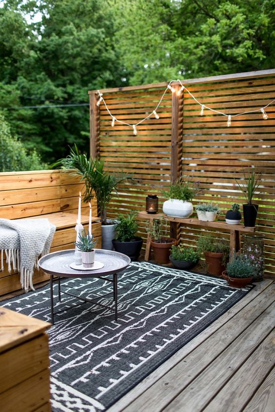 15 Deck Must Haves for Summer Entertaining; potted plants, privacy wall, outdoor hanging lights on deck 