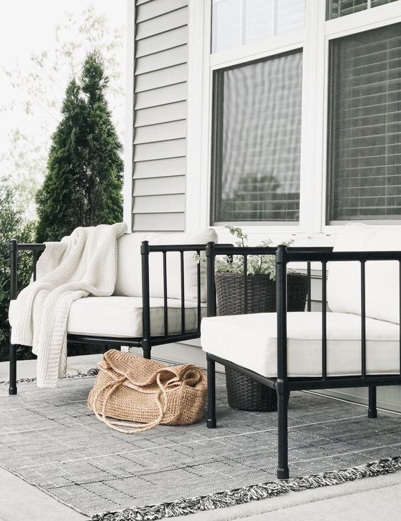 15 Deck Must Haves for Summer Entertaining; black iron rod outdoor chairs, white cushions, outdoor rug