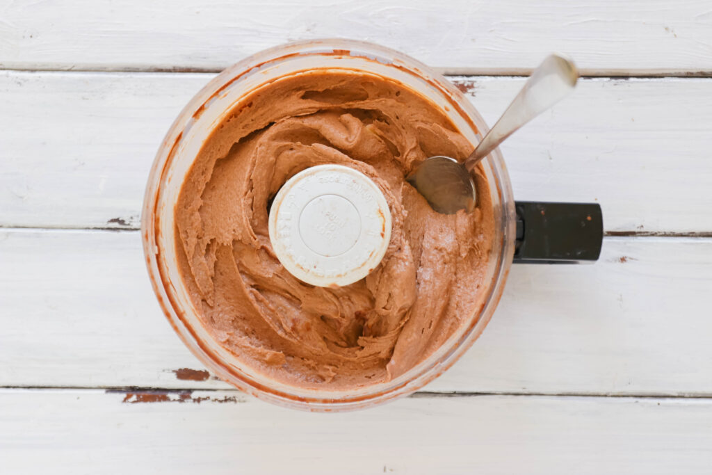 Food processor with ingredients for Chocolate Peanut Butter Ice Cream Cups; Vegan, dairy free and gluten free banana ice cream bites packed with cocoa and PB flavours.
