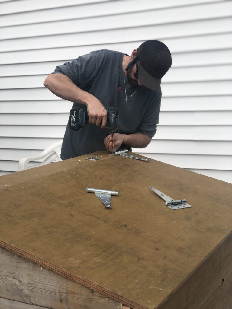 Drilling hinges onto outdoor garbage box lid for easy opening