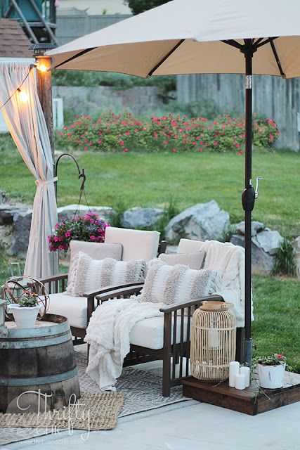 15 Deck Must Haves for Summer Entertaining; umbrella, comfy chairs with beige cushions, country farm decor