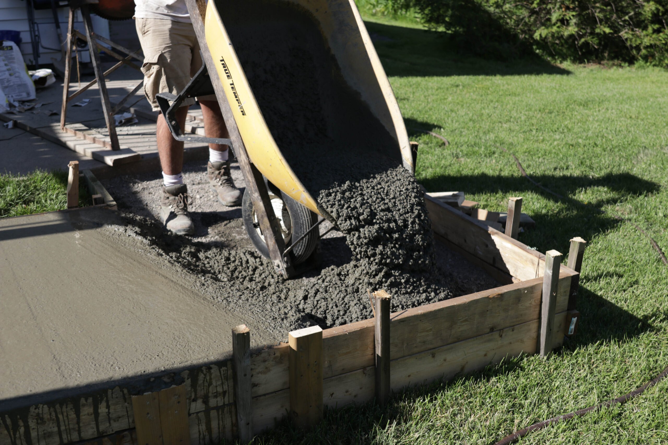 wheelbarrow pouring concrete for walkway