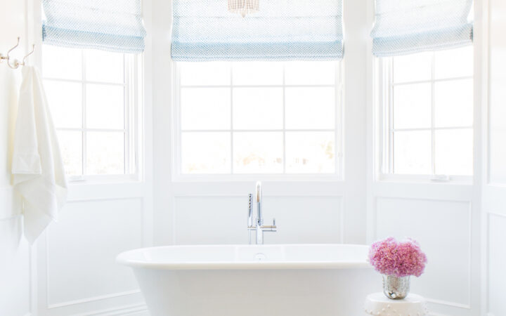 Bathrooms by Studio McGee; coastal bathroom, white tub, stand alone bathtub, chandelier