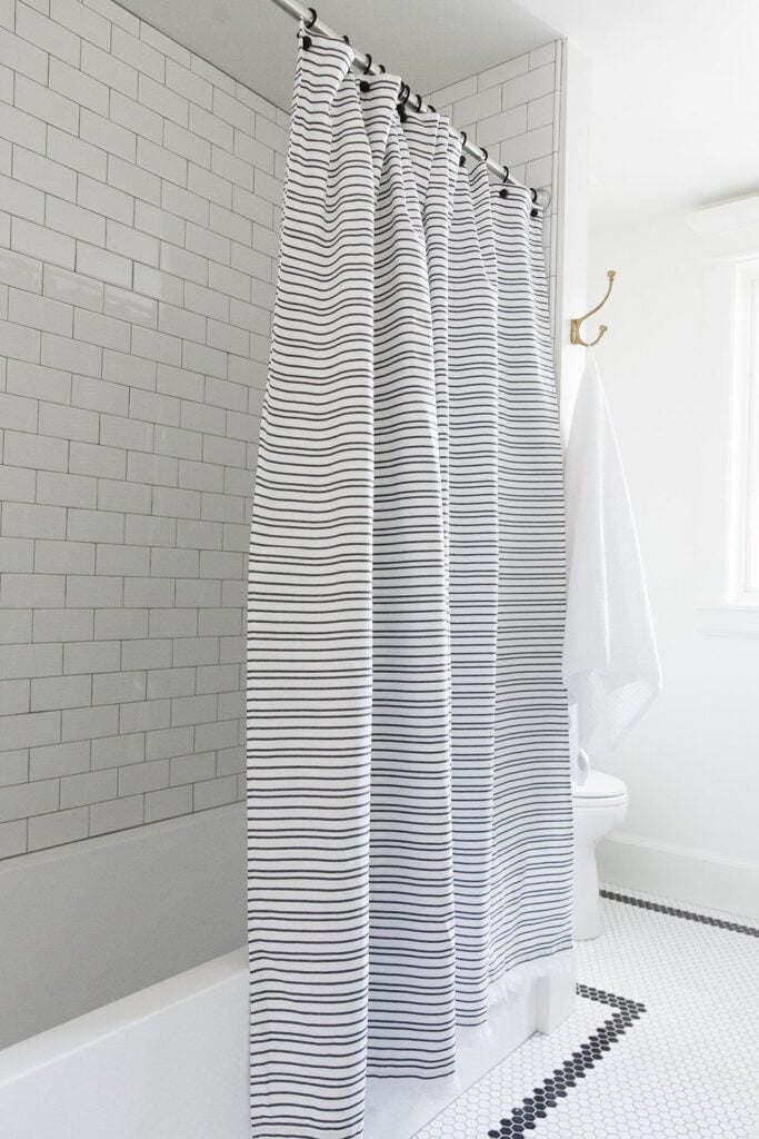 Bathrooms by Studio McGee;  stripped shower curtain, subway tile in shower