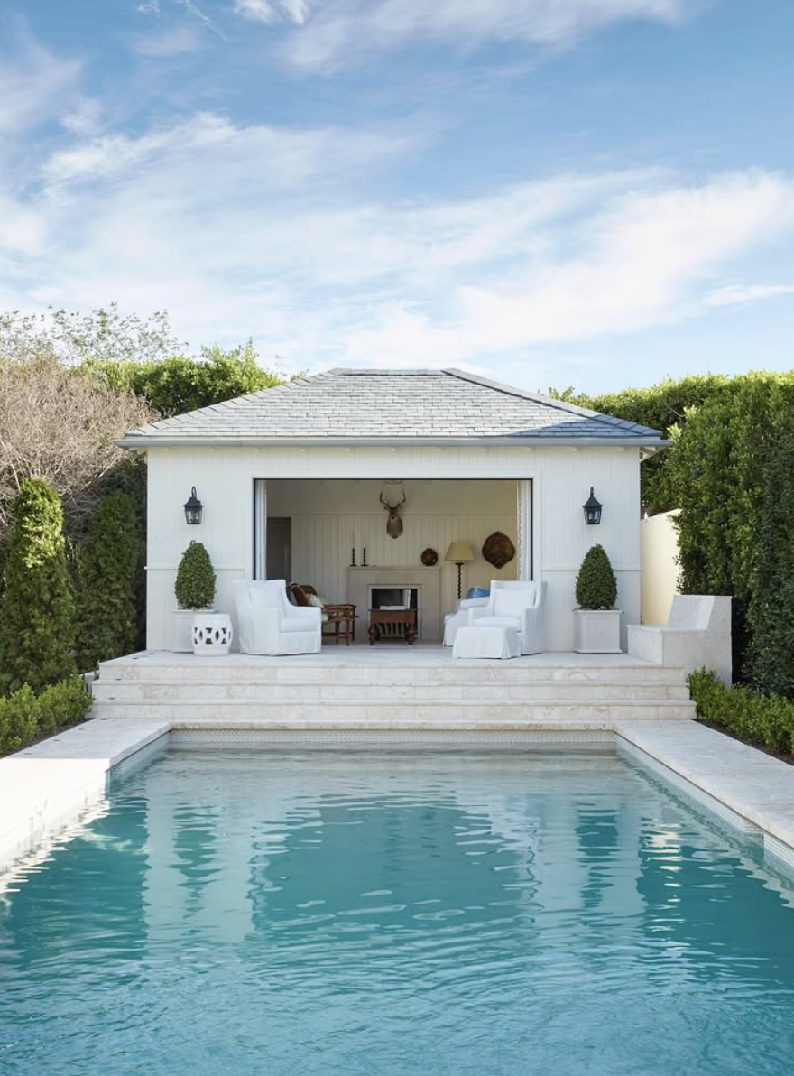minimalist white pool house with open front lounge and backyard swimming pool