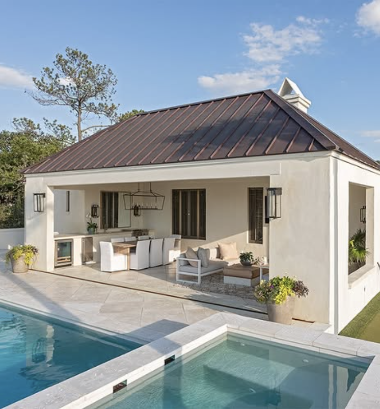 modern mediterranean style pool house with metal roof, covered patio, and outdoor dining beside swimming pool
