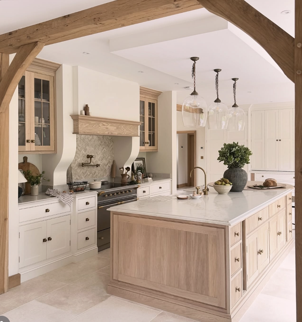 white oak kitchen with wood beams, marble island, and light wood cabinetry