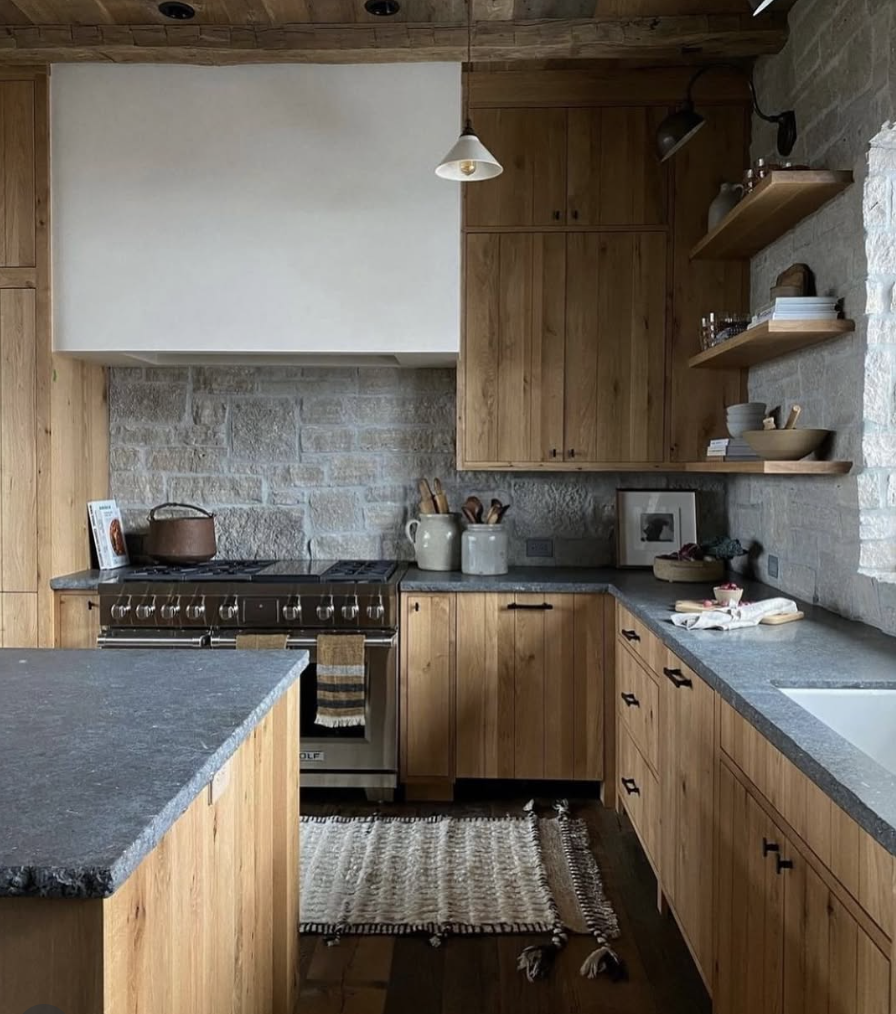 rustic kitchen with wood cabinets, soapstone countertops, and stone backsplash