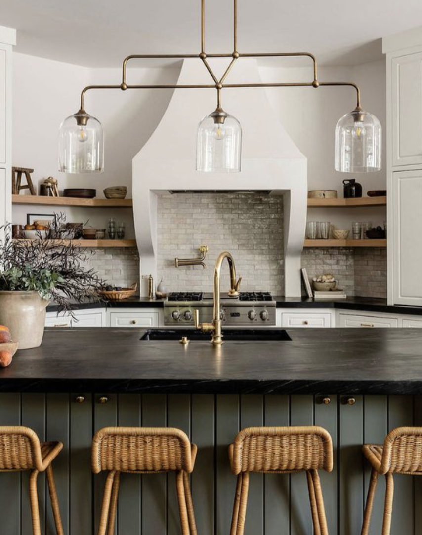kitchen with soapstone countertops, large island, brass lighting, and open shelving