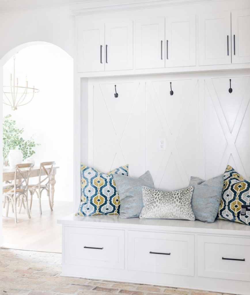 39 Tips to Decorate a Mudroom on a Budget; white cabinets, pillows on bench