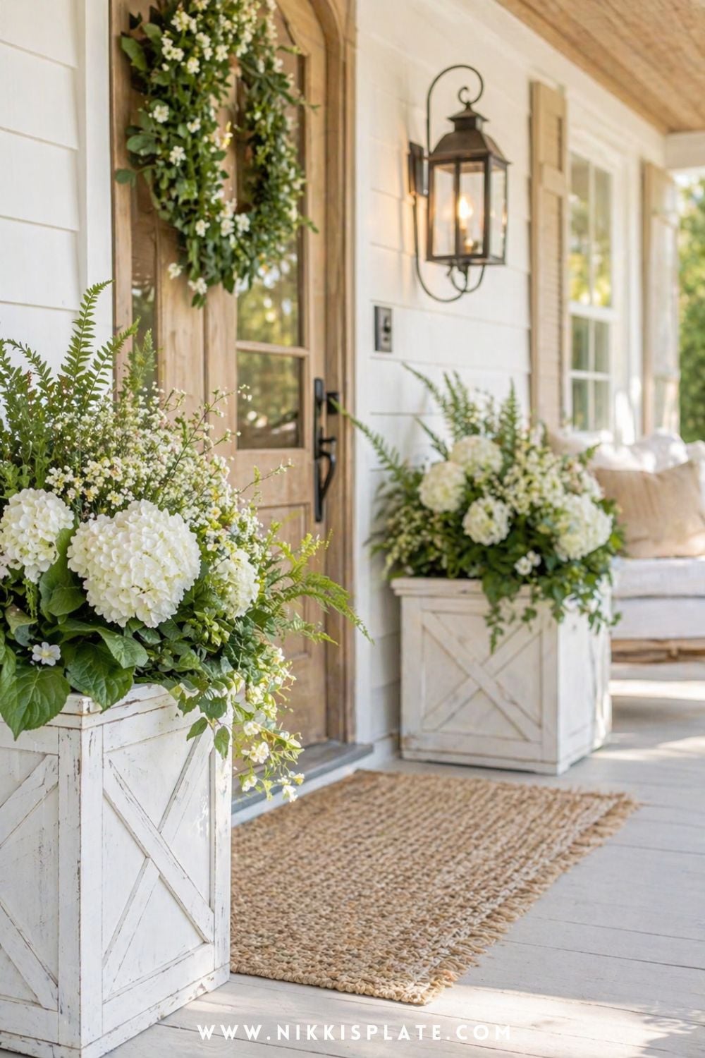 Farmhouse front porch planter ideas with white hydrangeas and greenery in wooden planters by the front door
