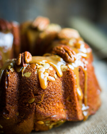 Pumpkin Apple Bundt Cake Recipe With Caramel Glaze; This delicious autumn bundt cake dessert is loaded with pumpkin spice, apples, pecans and drizzled with caramel glaze.