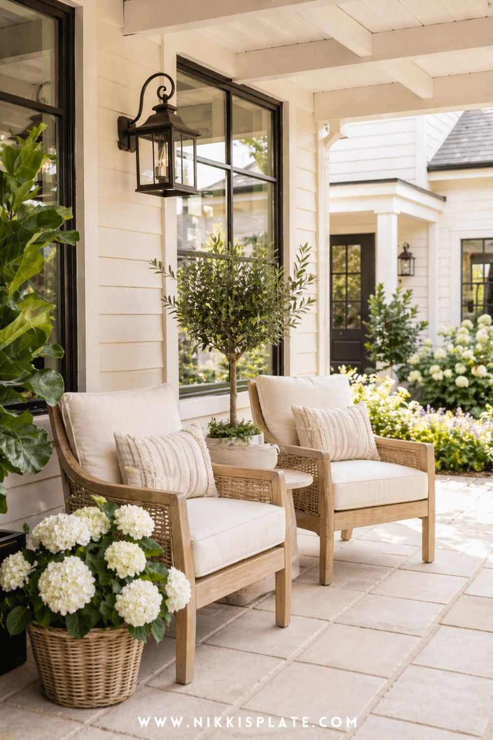 Cozy front porch planter ideas with white hydrangeas in a woven basket beside neutral outdoor seating