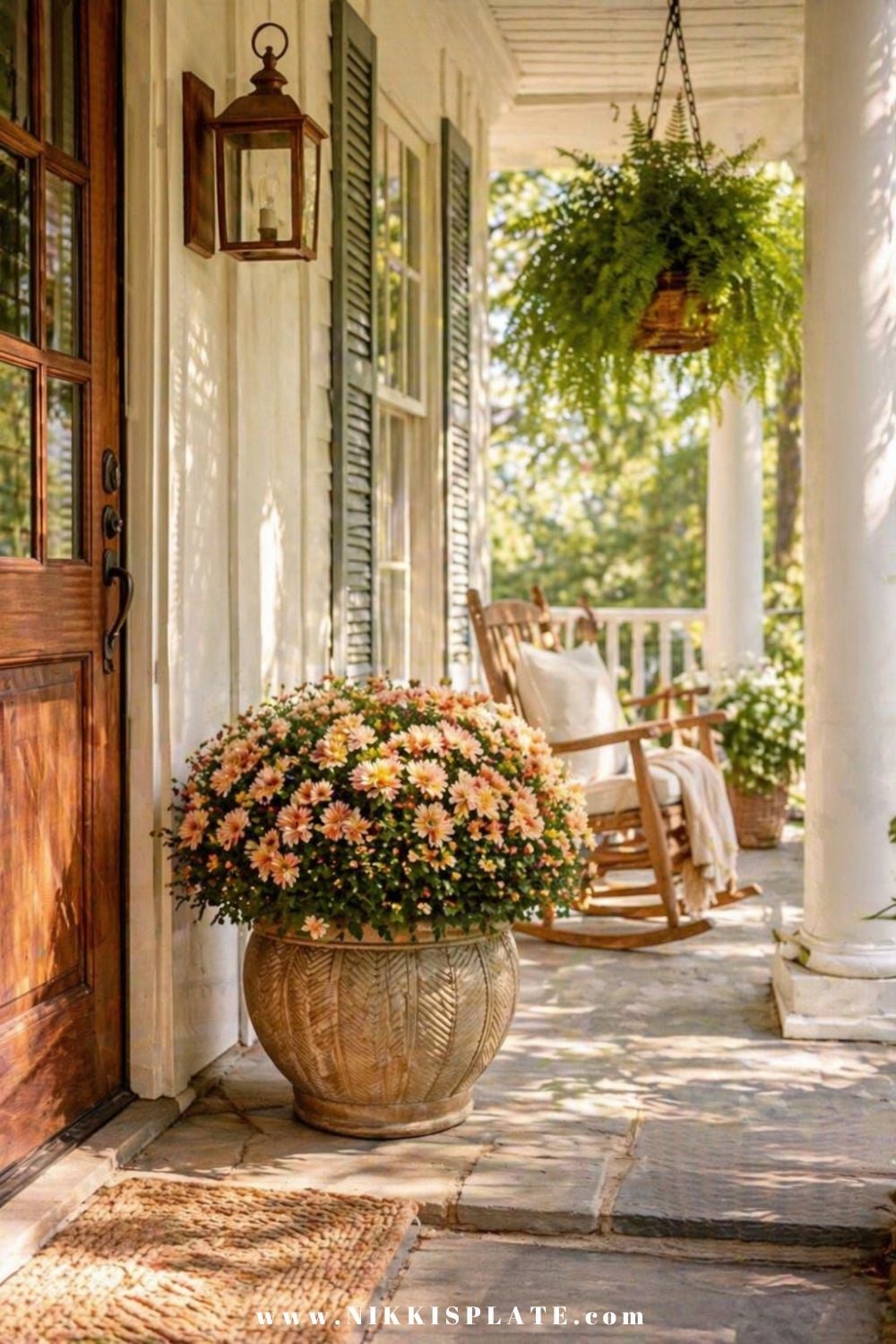 Front porch planter ideas with a large decorative pot filled with soft peach flowers on a welcoming front porch