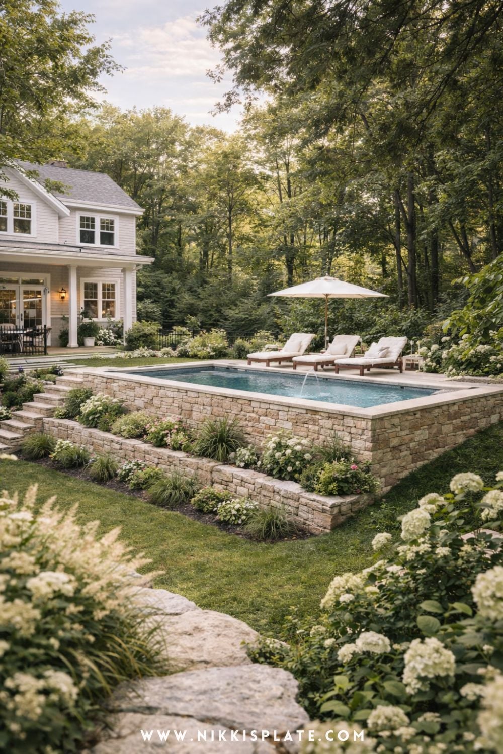 Farmhouse Hillside Pool with Retaining Walls and Lush Garden Landscaping. Hillside pool with retaining walls and layered stone landscaping in a farmhouse-style sloped backyard