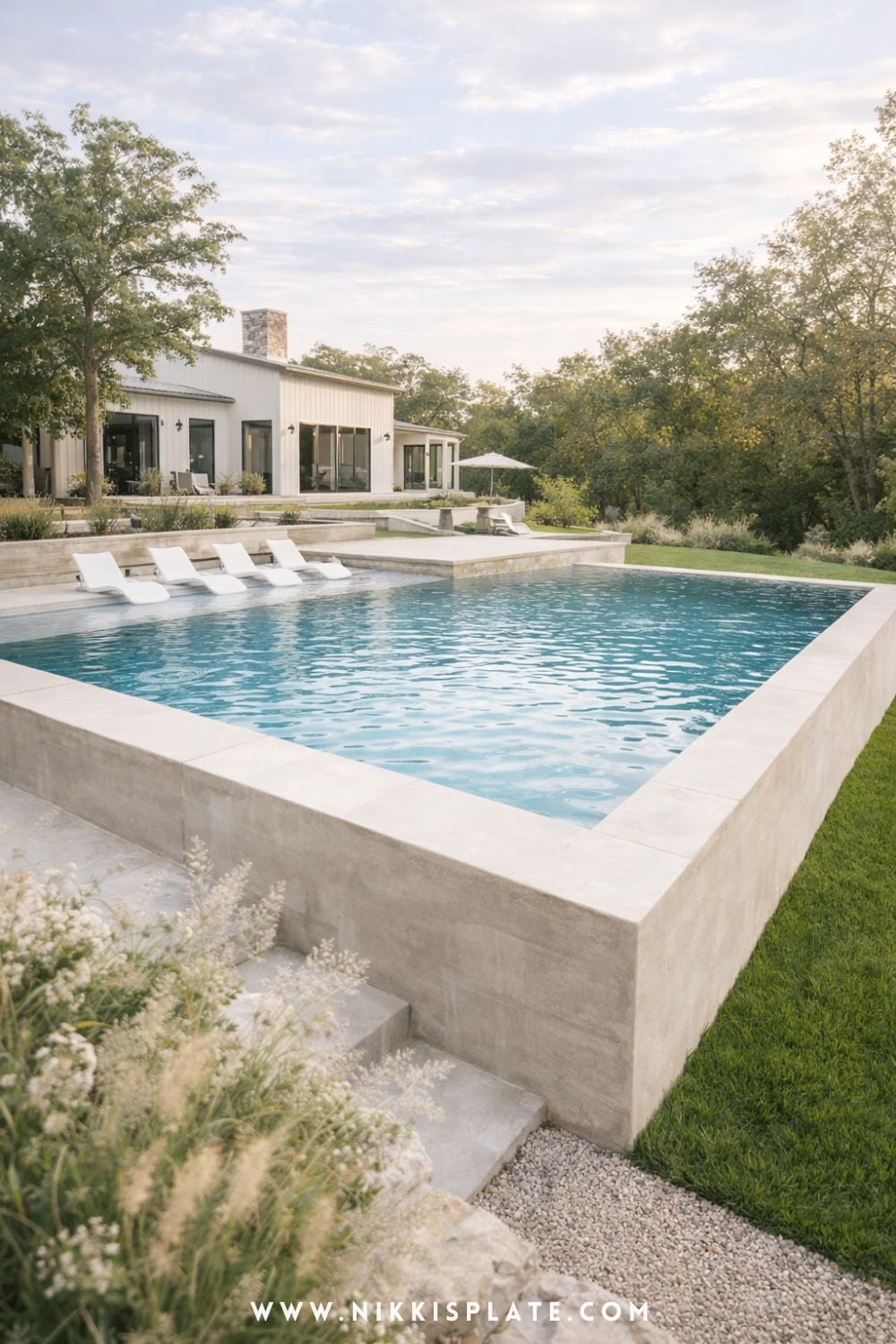 Modern hillside pool with retaining walls and clean concrete design in a sloped backyard with minimalist landscaping