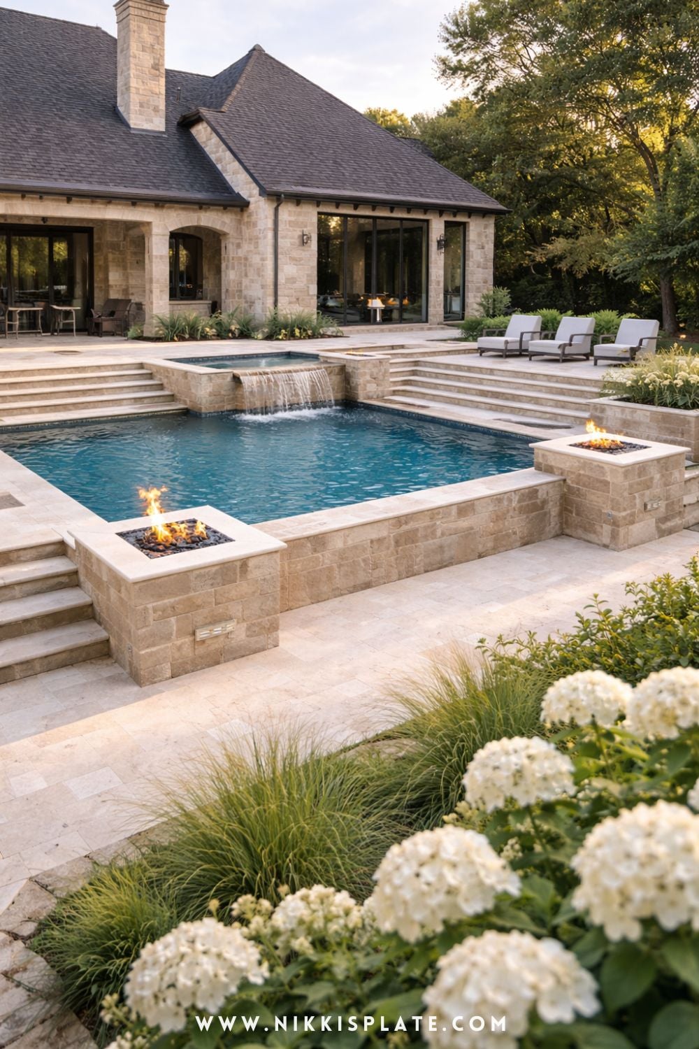 Hillside pool with retaining walls featuring stone design, fire bowls, and tiered layout in a sloped backyard